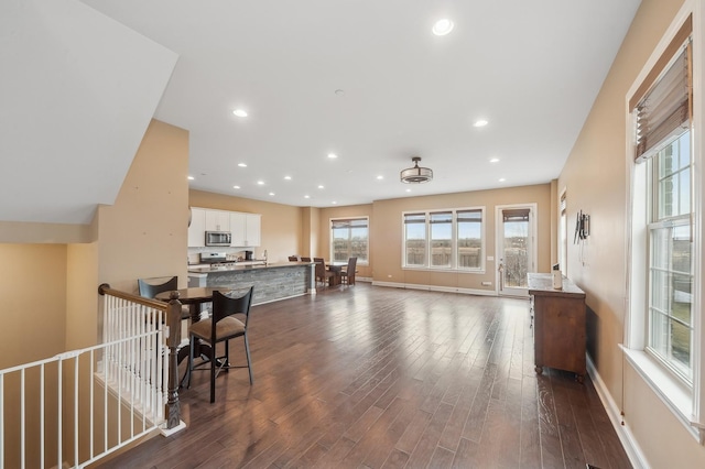 interior space featuring white cabinetry, a kitchen breakfast bar, dark hardwood / wood-style flooring, a center island, and stainless steel appliances