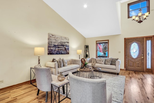 living area featuring high vaulted ceiling, a chandelier, baseboards, and hardwood / wood-style flooring