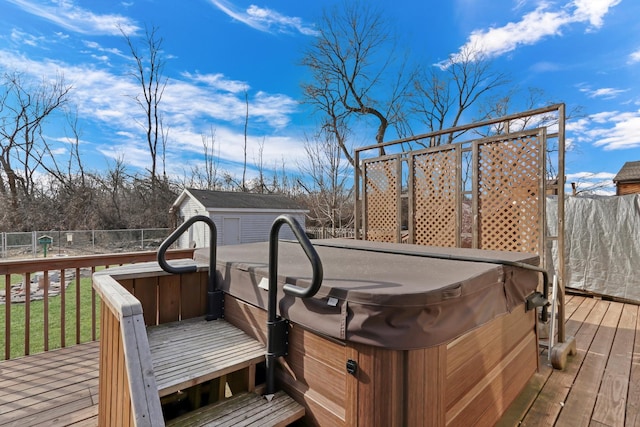 wooden terrace with an outdoor structure, fence, and a hot tub