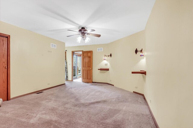 carpeted empty room with baseboards, visible vents, and ceiling fan