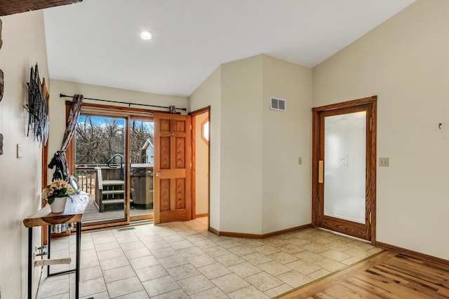 doorway to outside with visible vents, baseboards, and wood finished floors