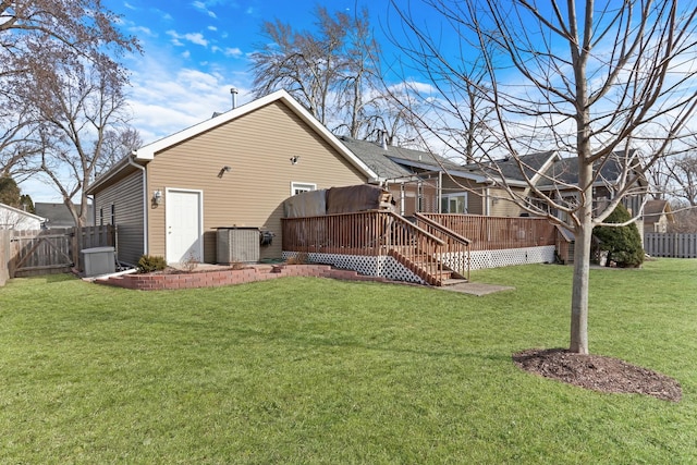 back of house featuring fence, a deck, central AC unit, and a lawn