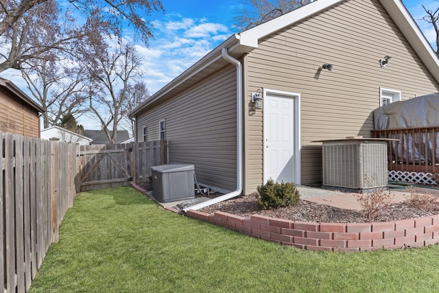 back of property with a lawn, cooling unit, and a fenced backyard