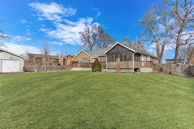 rear view of property featuring a sunroom, fence, a deck, and a yard