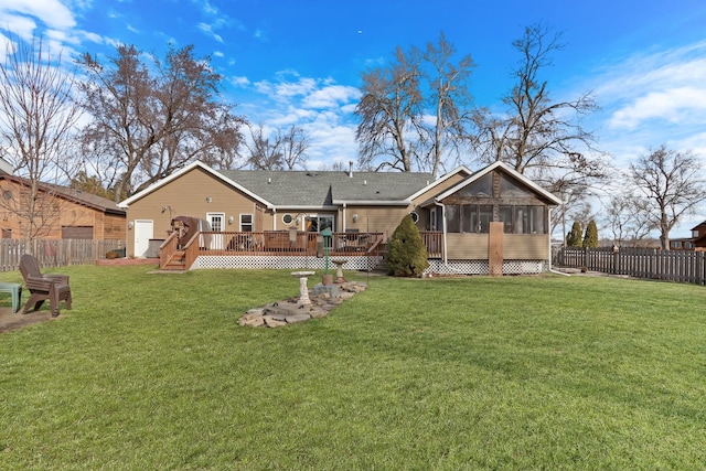 back of property with a sunroom, a fenced backyard, a deck, and a yard