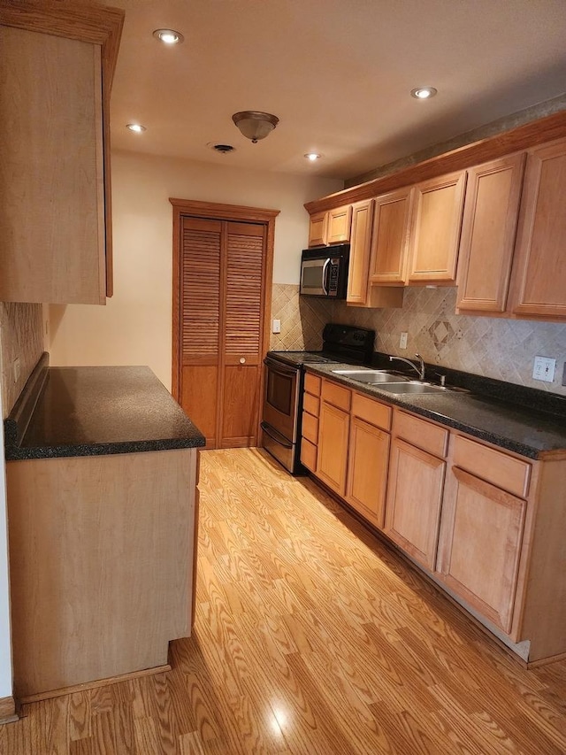 kitchen featuring tasteful backsplash, sink, light hardwood / wood-style flooring, and stainless steel electric range