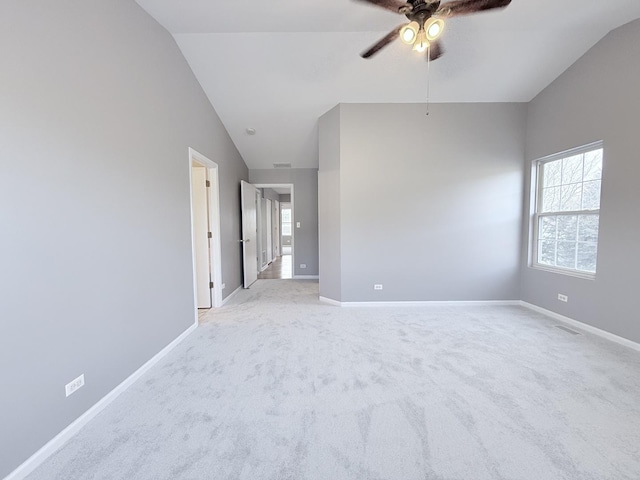 carpeted empty room featuring ceiling fan and vaulted ceiling