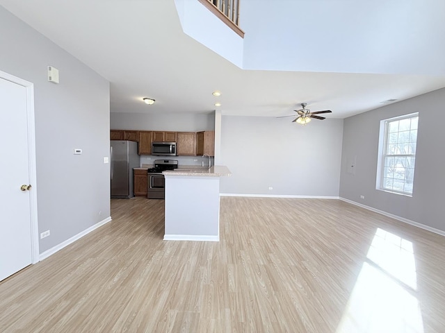 kitchen featuring sink, light hardwood / wood-style floors, stainless steel appliances, and ceiling fan