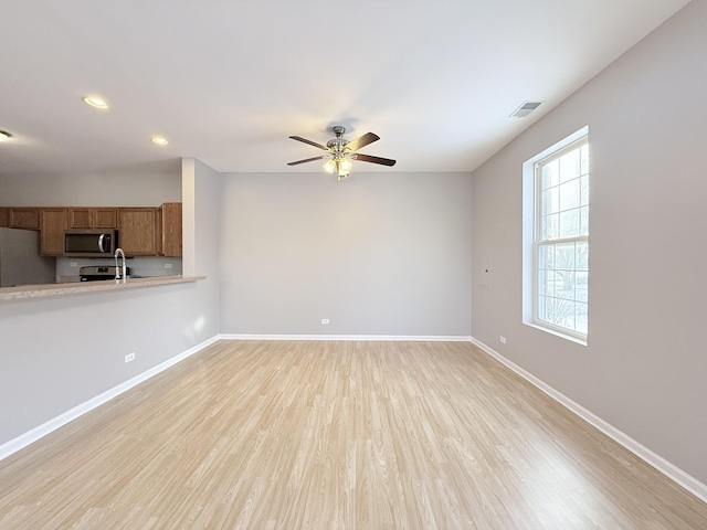 unfurnished living room featuring ceiling fan and light hardwood / wood-style flooring