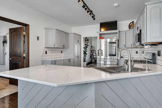 kitchen with gray cabinetry, sink, kitchen peninsula, and appliances with stainless steel finishes