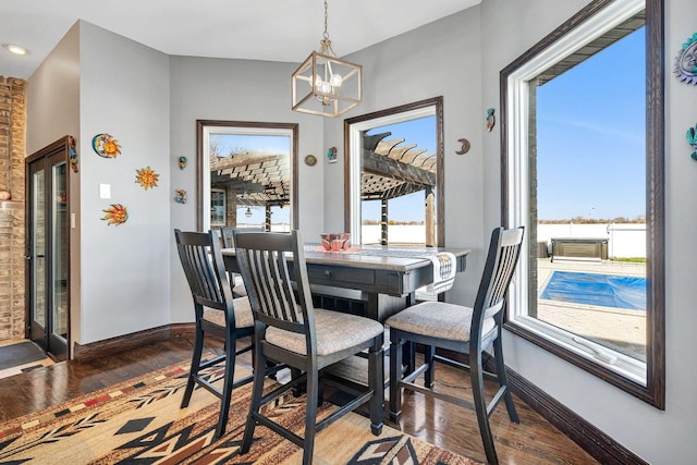 dining space with an inviting chandelier and dark hardwood / wood-style floors