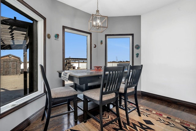 dining area with an inviting chandelier and dark hardwood / wood-style floors