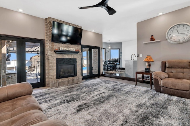 living room with hardwood / wood-style flooring, a healthy amount of sunlight, a fireplace, and ceiling fan