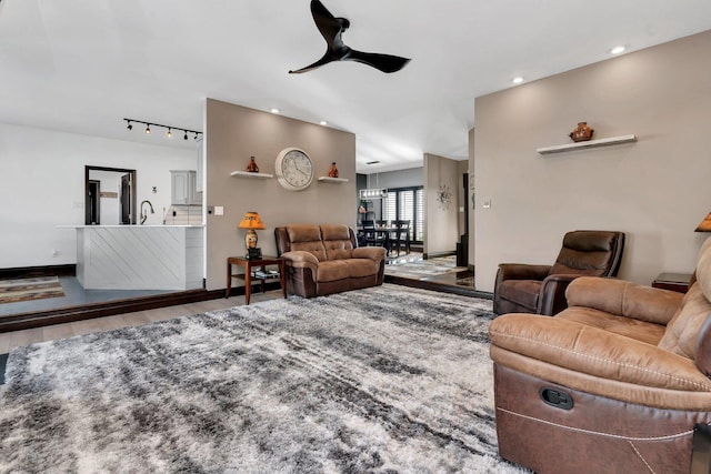 living room with wood-type flooring, rail lighting, and ceiling fan