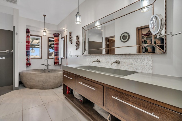 bathroom featuring tile patterned flooring, backsplash, a bathtub, and vanity