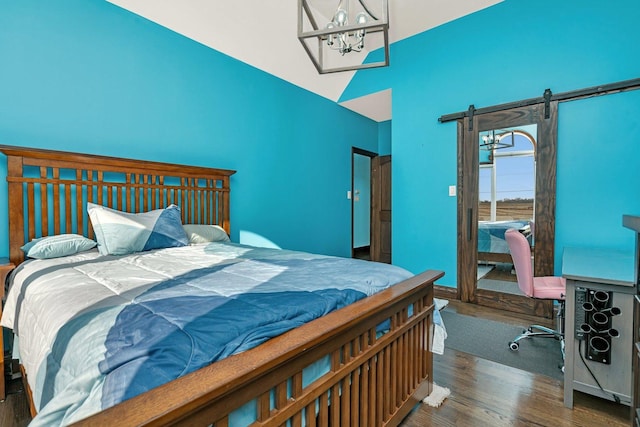 bedroom with lofted ceiling, access to outside, dark hardwood / wood-style floors, and a barn door