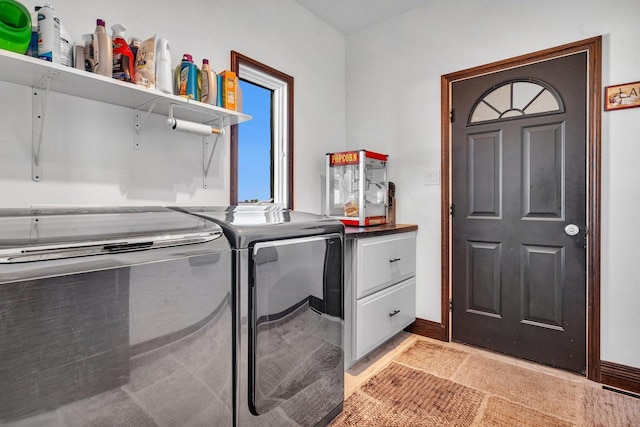 clothes washing area featuring cabinets and washing machine and clothes dryer