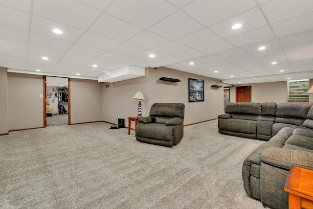 carpeted living room featuring a drop ceiling