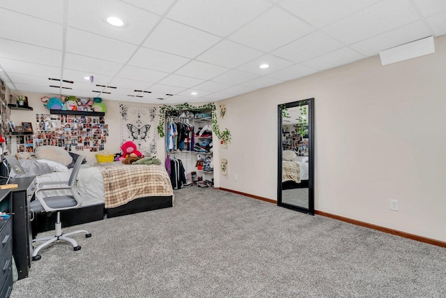 carpeted bedroom with a drop ceiling