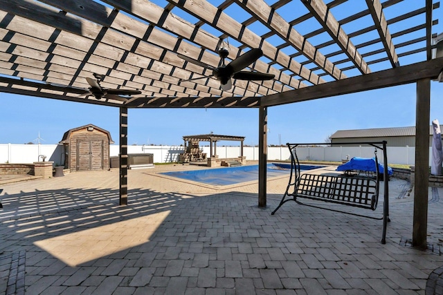 view of patio featuring ceiling fan, a storage unit, a pergola, and a covered pool