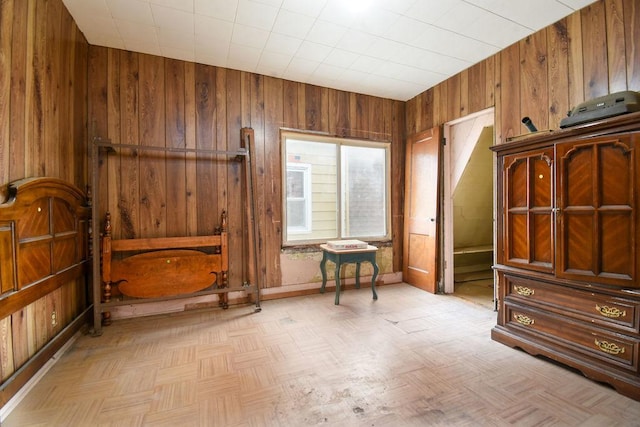 sitting room with light parquet flooring and wood walls