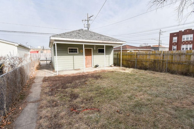 back of house featuring a lawn