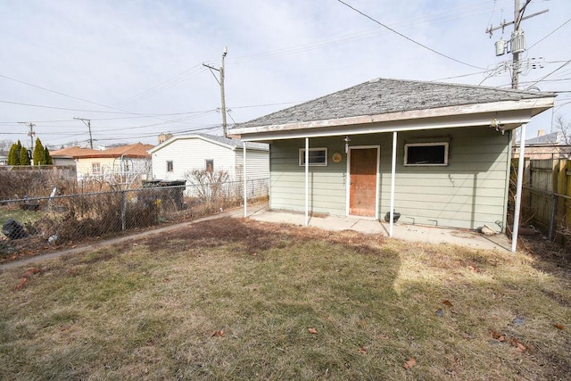 rear view of property featuring a lawn