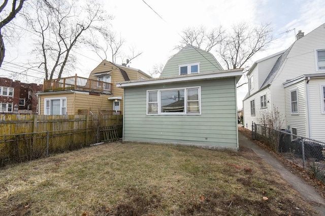 rear view of property featuring a lawn