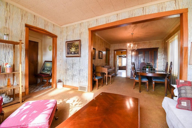 dining area with crown molding, carpet floors, and a chandelier