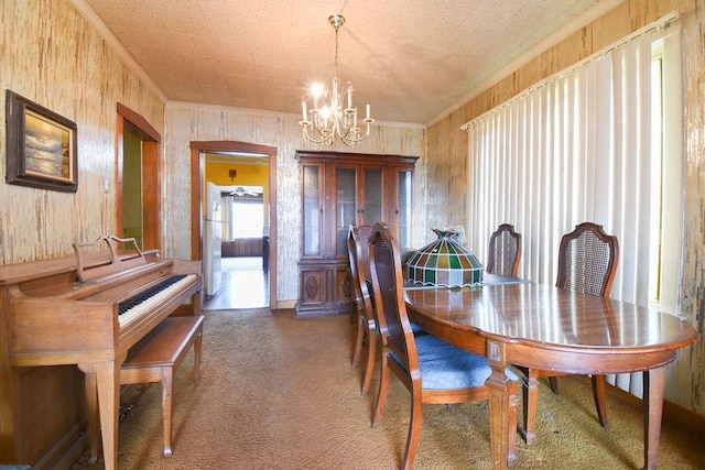 carpeted dining space with an inviting chandelier and ornamental molding