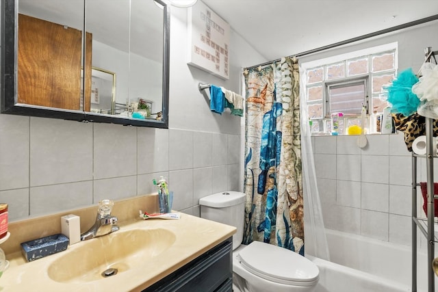 full bathroom with shower / bath combination with curtain, vanity, toilet, and tile walls