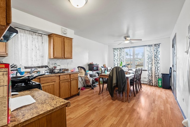 kitchen with decorative backsplash, light hardwood / wood-style floors, ceiling fan, and black gas stove