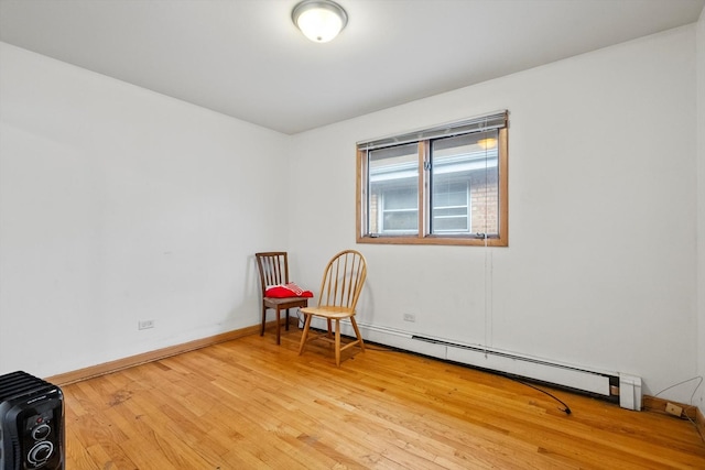 empty room featuring baseboard heating and light wood-type flooring