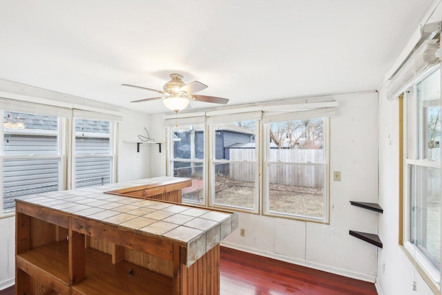 sunroom / solarium featuring ceiling fan and a wealth of natural light