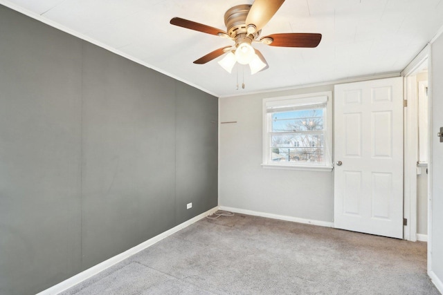 spare room with crown molding, ceiling fan, and light carpet