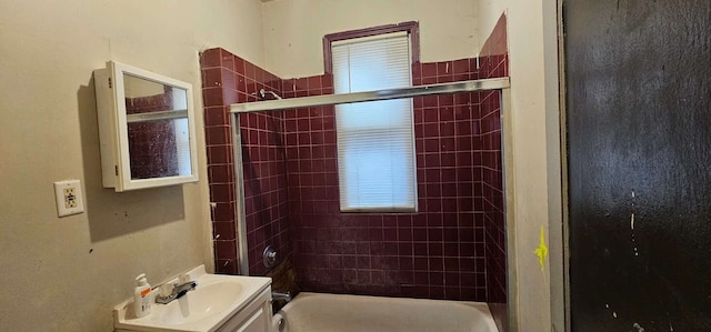 bathroom with tiled shower / bath combo and vanity