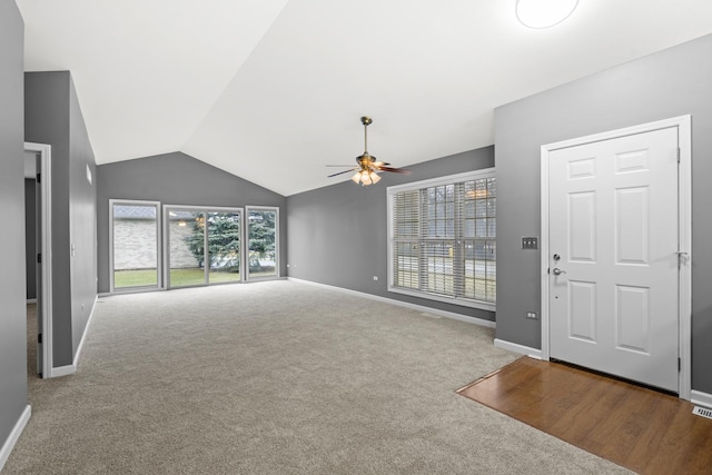 unfurnished living room featuring vaulted ceiling, ceiling fan, and carpet