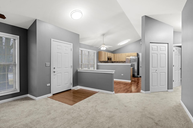 kitchen featuring light brown cabinetry, light colored carpet, vaulted ceiling, appliances with stainless steel finishes, and ceiling fan