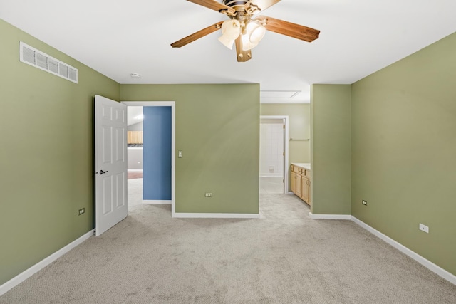 unfurnished bedroom with ceiling fan, light colored carpet, and connected bathroom