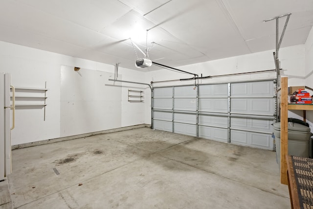 garage featuring white refrigerator and a garage door opener