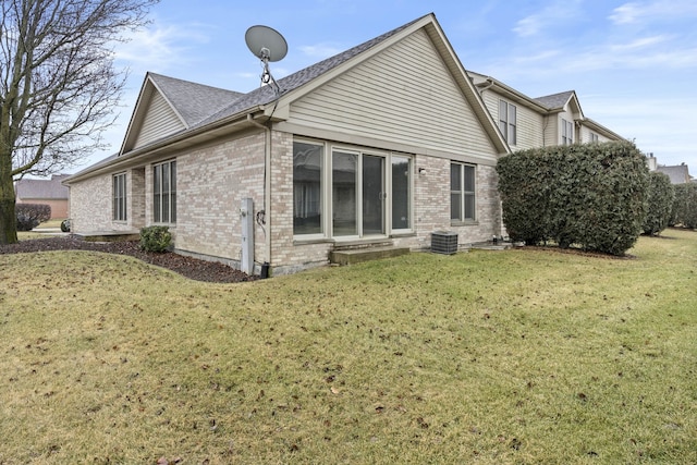 back of property with cooling unit and a lawn