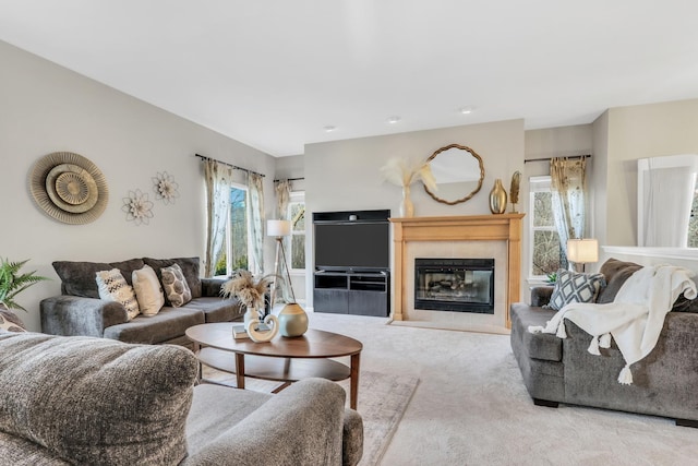 living room with light colored carpet and a tiled fireplace