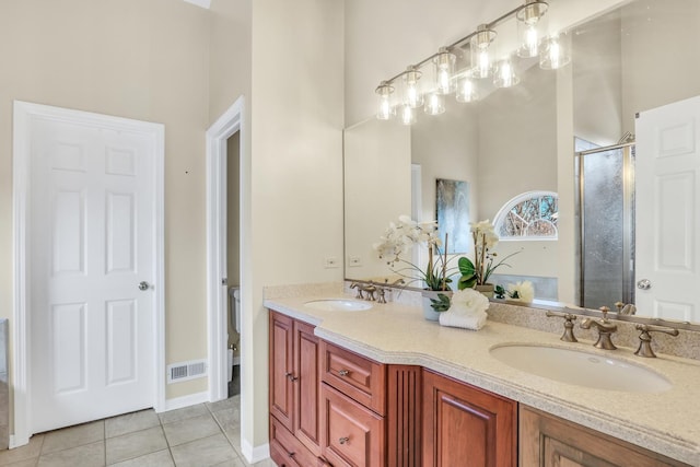 bathroom featuring tile patterned floors, a shower with door, and vanity