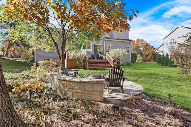 view of yard with a wooden deck, a patio, and a fire pit