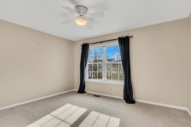 carpeted spare room with ceiling fan