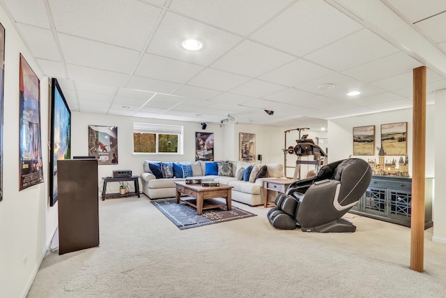 living room featuring carpet floors and a drop ceiling