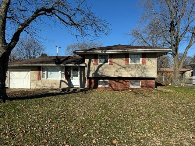 tri-level home with a garage and a front yard