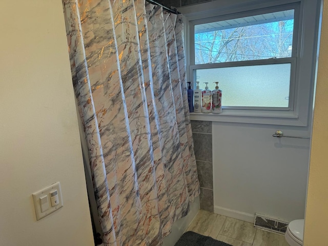 bathroom with curtained shower and toilet