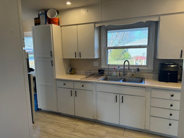 kitchen featuring white cabinetry and sink