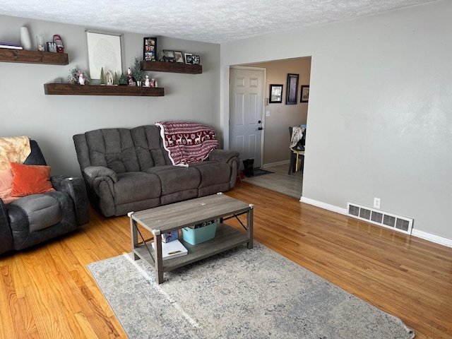 living room featuring hardwood / wood-style floors and a textured ceiling